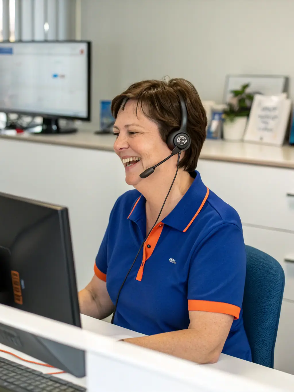A professional headshot of a friendly customer service representative, smiling and wearing a headset, symbolizing the email support offered in the Basic Plan.